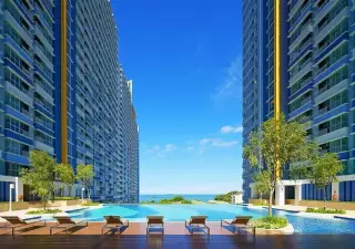 Lumpini Park Beach Jomtien infinity pool with sun loungers between high-rise towers and sea view