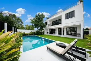 Highgrove Villas modern white two-story house exterior with black accents, balconies, covered parking, and landscaping.