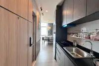 1 Bedroom Condo for Sale at The Twin Tower Jomtien Beach Pattaya narrow kitchen with dark cabinets, black countertop, and view to dining area
