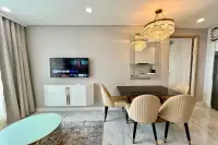 1 Bedroom Condo for Rent at Copacabana Beach Jomtien living and dining area with crystal chandelier, smart TV, and gold chairs