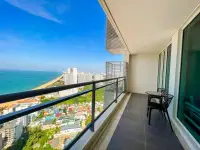 2 Bedroom Condo for Sale at Reflection Jomtien Beach high-floor balcony with table, chairs and coastal city view