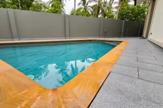 Amarin House 2 private outdoor swimming pool with golden stone coping, granite deck, and tropical palm surroundings