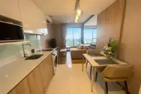 1 Bedroom Condo for Rent at Once Pattaya modern kitchen with white countertops, dining area, and floor-to-ceiling windows with city view