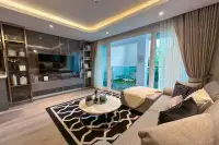 2 Bedroom Condo for Sale at Pristine Park 3 living room with dark marble TV wall, built-in shelving, and sliding doors to terrace at night