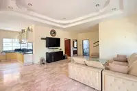 3 Bedroom House for Sale at Mike Orchid Villas 2, spacious living room with sofa, TV, and view of the kitchen.