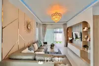 3 Bedroom House for Sale at Baan Pruksa Nara Chaiyapruek: living room with L-shaped sofa, chandelier, and modern wall decor.