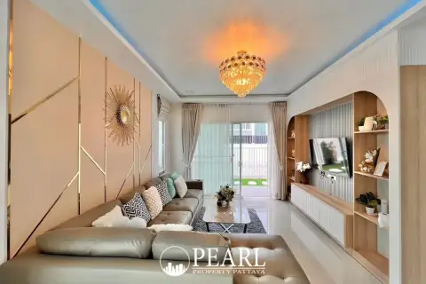 3 Bedroom House for Sale at Baan Pruksa Nara Chaiyapruek: living room with L-shaped sofa, chandelier, and modern wall decor.