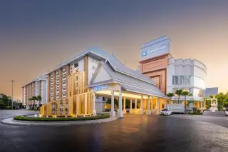 Wyndham Jomtien Pattaya main entrance at dusk with a golden sculpture and traditional Thai roof design.
