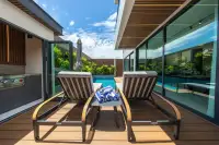 5 Bedroom House for Sale in Bang Lamung poolside terrace with sun loungers, rolled towels and glass wall overlooking pool