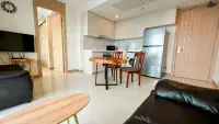2 Bedroom Condo for Sale at The Riviera Jomtien dining area with kitchen, fridge, and black sofa
