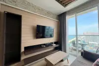 1 Bedroom Condo for Sale at Cetus Beachfront living room TV wall unit with balcony and panoramic Pattaya beach and city view