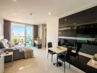 1 Bedroom Condo for Sale at The Vision open-plan living room with dining table, black kitchen cabinets, and city balcony view