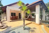 3 Bedroom House for Sale at Mike Orchid Villas 2, side exterior with covered patio, outdoor dining, and sun loungers.