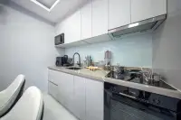 2 Bedroom Condo for Sale at Grand Solaire Noble modern kitchen with white gloss cabinets, marble countertop, and built-in oven