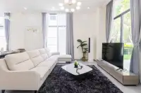 4 Bedroom House for Sale at Tadarawadi South Pattaya: Modern living room with a white sectional sofa and large TV.