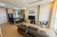 1 Bedroom Condo for Rent at Cetus Beachfront spacious living room with grey sofa, flat-screen TV, dining area, and open kitchen