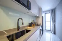 1 Bedroom Condo for Sale at Grand Solaire Noble modern kitchen with grey countertop, black sink, glass backsplash, and balcony