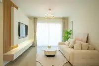 3 Bedroom House for Sale at Baan Pruksa Nara Chaiyapruek bright living room with beige sofa wood slat TV wall and round pendant light
