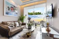 1 Bedroom Condo for Sale at The Riviera Palm Beach living room with brown sofa, coffee table, and balcony view.