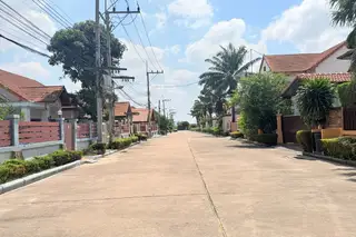 Mike Orchid Villas 2 residential street with houses, palm trees, and power lines on a sunny day.
