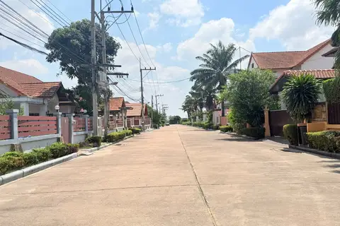 Mike Orchid Villas 2 residential street with houses, palm trees, and power lines on a sunny day.