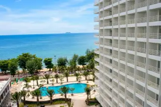 View Talay 7 balcony view overlooking curved swimming pool, beach, and ocean horizon