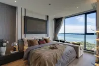 1 Bedroom Condo for Sale at Andromeda Condominium luxury bedroom with upholstered headboard, bedside lamps, and floor-to-ceiling sea view