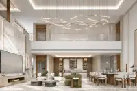 5 Bedroom House for Sale at Patta Riverine double-height living room with marble walls, fireplace, and sculptural chandelier