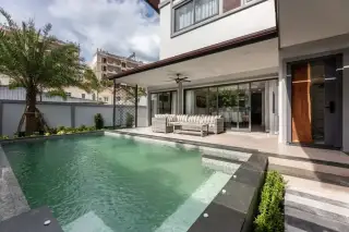 Zensiri Midtown Villas private pool and poolside lounge area with rattan sofa, glass sliding doors and tropical garden