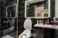 1 Bedroom Condo for Sale at Grand Solaire Pattaya: Bathroom with toilet, sink, mirror, and dark tiled walls.
