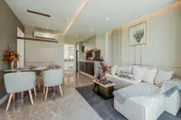 2 Bedroom Condo for Sale at The Coral Pattaya: open-plan living room, dining area, and kitchen with modern appliances.