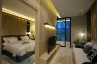 1 Bedroom Condo for Sale at SKYPARK Lucean Jomtien Pattaya night-lit living room with open bedroom, TV unit, sofa and panoramic city-view windows