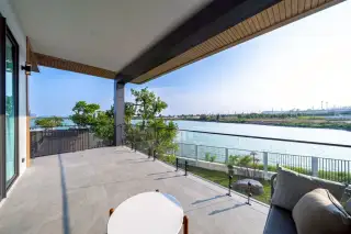 M Mountain Lake spacious balcony overlooking a serene lake and lush greenery under a clear sky.