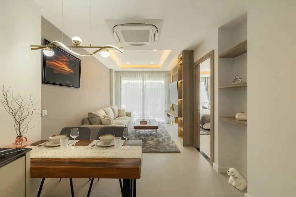 1 Bedroom Condo for Sale at Zensiri Estates and Residences open-plan living and dining area with wood dining table and modern chandelier