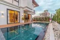 3 Bedroom House for Sale in Huai Yai private pool with wood deck and lit interior at dusk