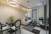 1 Bedroom Condo for Sale at Embassy Life dining area with round chandelier, table set for two, and adjacent living room.