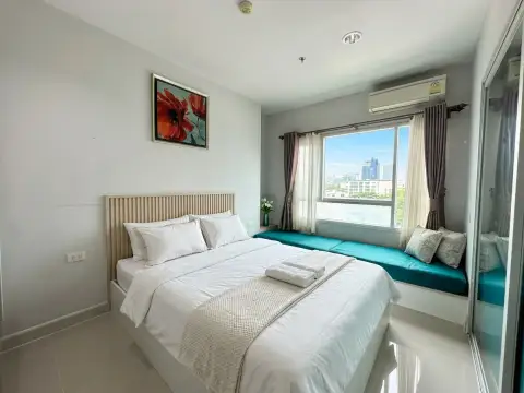 1 Bedroom Condo for Sale at Centric Sea bedroom with window seat, city view, and floral wall art
