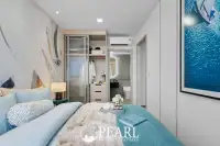 2 Bedroom Grand Executive Condo for Sale at Aquarous Jomtien Pattaya: Bedroom with bed, built-in wardrobe, and ensuite bathroom entrance.