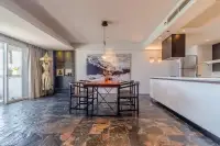 2 Bedroom Condo for Sale at Grand Condotel open-plan dining area with marble stone floors, wood table, and modern kitchen