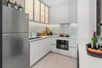 2 Bedroom Condo for Sale at Once Wong Amat modern white L-shaped kitchen with stainless steel fridge, oven, and under-cabinet lighting