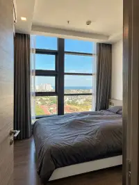 2 Bedroom Condo for Sale at Pattaya Posh bedroom with ocean and city skyline view through glass walls