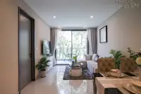 2 Bedroom Condo for Sale at Copacabana Coral Reef living room with balcony sliding door overlooking lush garden and outdoor seating