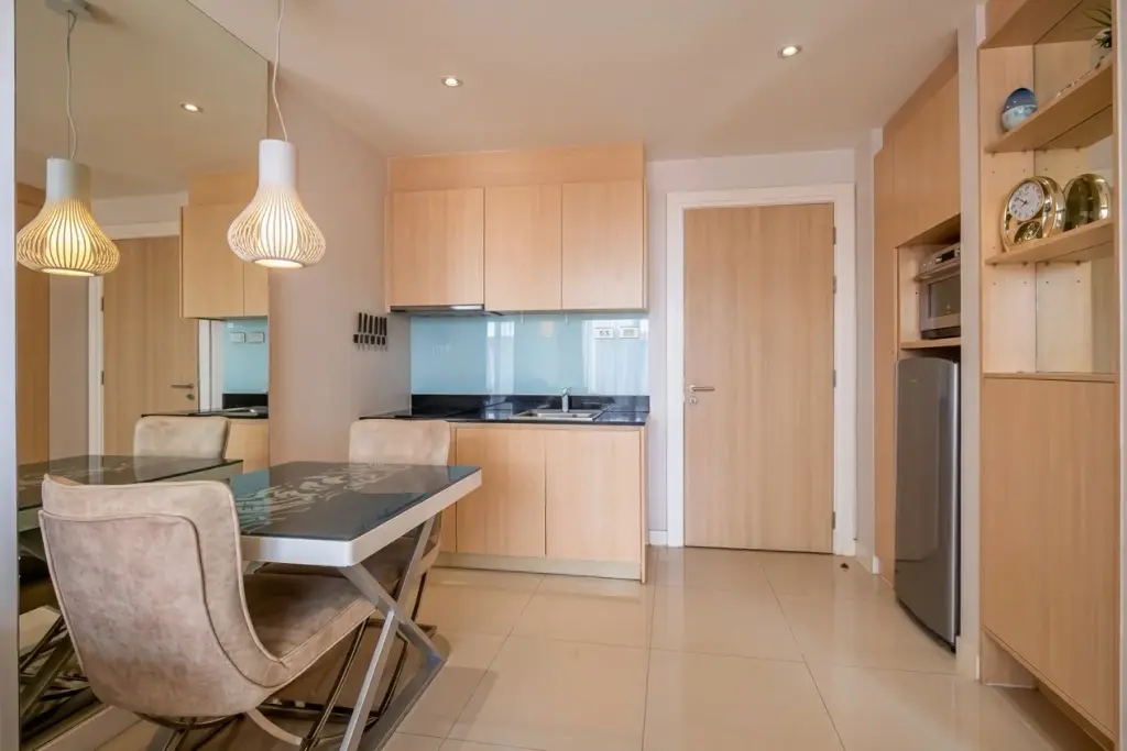 1 Bedroom Condo for Sale at Grande Caribbean kitchen with wood cabinetry and dining table seating