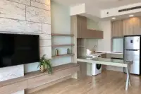 1 Bedroom Condo for Sale at Cetus Beachfront open-plan living area with marble TV wall and modern kitchen