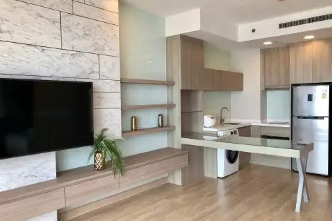 1 Bedroom Condo for Sale at Cetus Beachfront open-plan living area with marble TV wall and modern kitchen