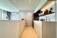 2 Bedroom Condo for Sale at Celine Wongamat galley kitchen with wood cabinets stainless steel fridge and built-in washing machine