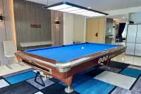 1 Bedroom Condo for Sale at Gardenia Pattaya GRB billiards table under pendant light with textured grey accent wall and mirrored panels