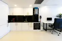 2 Bedroom Condo for Sale at Grand Avenue Residence: Modern kitchen with white cabinets, black countertops, and desk area.