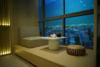 Studio Condo for Sale at SKYPARK Lucean Jomtien Pattaya cozy window seat lounge area with panoramic Jomtien beach view at dusk