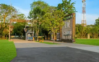 TW. Garden Hill main entrance gate with security booth, large sign, and construction area in Pattaya.